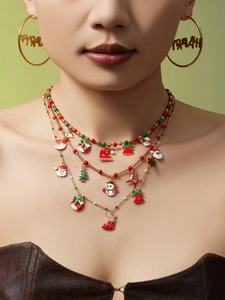 Close-up of three-layer Christmas necklace with enamel charms and Happy hoop earrings