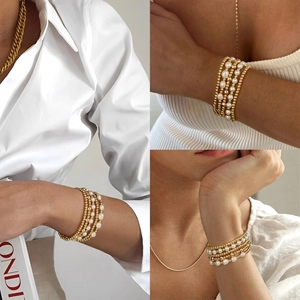 Elegant layered gold bead and pearl stack bracelet set, minimalist fashion jewelry for women.