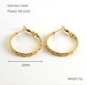 Dettaglio macro di orecchini a cerchio 30mm in acciaio placcato oro 18k con cuori
