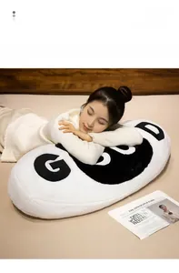 Soft white plush bolster pillow with black GOOD text used by a model for sleeping comfort