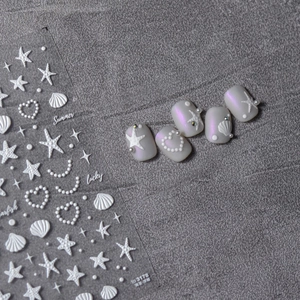 Detail of 3D embossed shell and starfish nail stickers on purple matte manicure finish