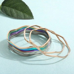 Nahaufnahme gewellter Armreifen in Gold, Silber und Regenbogen-Finish aus Edelstahl