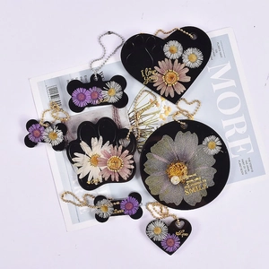 Detail van hars huisdierlabels met droogbloemen, bot- en hartvormen met gouden tekst