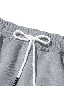 Détail macro du pantalon de sport en maille grise avec cordon de serrage blanc à la taille