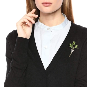 Spilla a fiore in zircone vintage con foglie verdi su camicia bianca e cardigan nero