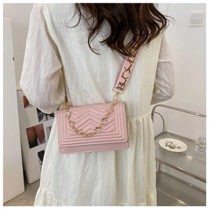 Close-up of pink V-quilted small square bag with embroidery and gold chain straps