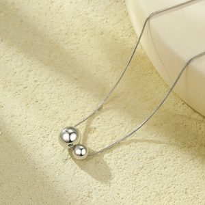 Minimalist stainless steel necklace featuring polished double hollow sphere pendants