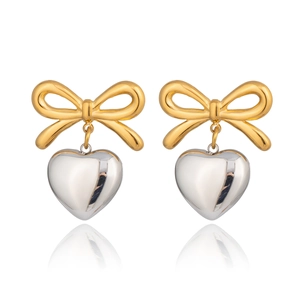 Detail of mixed-metal bow earrings with gold-toned ribbon and silver heart pendant