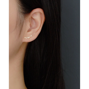 Close-up of elegant gold S925 silver stud earrings with sparkling zircon on ear