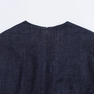 Detail van de achterkant van de kraag en de blinde rits van deze denim jurk