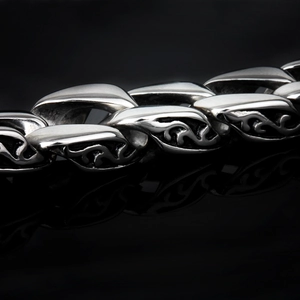 Macro shot of vintage totem engravings on oxidized stainless steel bracelet links