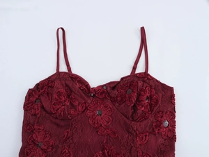 Detail of wine red lace bodice with 3D floral embroidery and silver sequins on dress