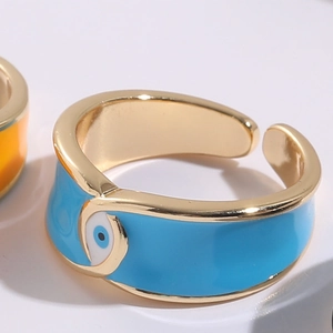 Detail of the 14K gold-plated evil eye ring featuring vibrant blue enamel and open band