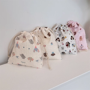 Close-up of four-piece seersucker drawstring bags with cute cartoon animal patterns