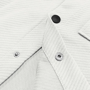 Detail shot of heavy twill fabric with black metal snaps and reinforced double stitching