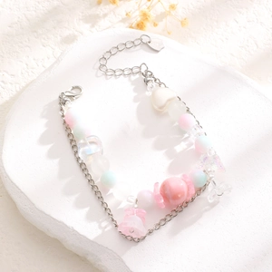 Vista macro de pulsera de cuentas macaron con dijes de corazón en piedra blanca
