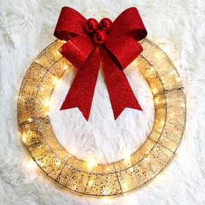 Detail of metal Christmas wreath with LED lights and a large red glittery bow
