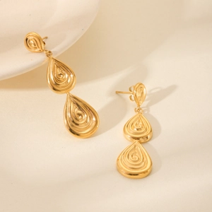 Macro shot of 18K gold triple water drop earrings with spiral relief texture design