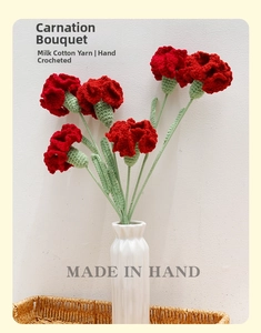 Detailed close-up of six handmade crochet red carnations in a white ceramic vase