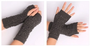 Detail showing dark grey knitted fingerless gloves with ribbed cuffs and wave texture