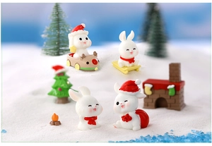 Detailed view of miniature Christmas resin rabbits in a snowy festive holiday landscape