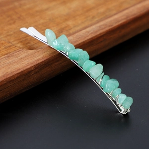Detailed close-up of a handmade turquoise stone hair clip with silver wire weaving
