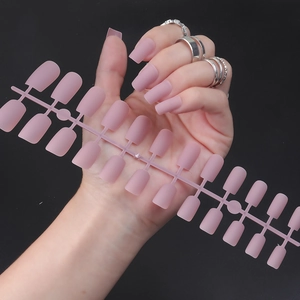 Detail of matte mauve square fake nails showing various sizes and worn on a hand