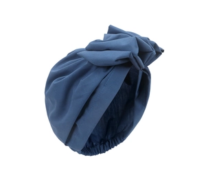 Detailed view of dark blue turban hat featuring a 3D floral pleated design on white background