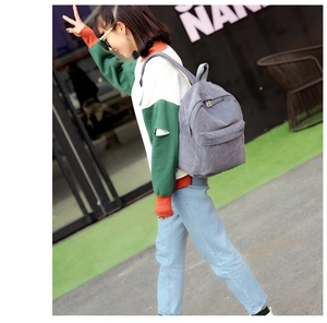 Gray corduroy backpack for women shown on model in a stylish urban street setting