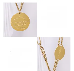 Detailed macro view of dual round pendants with BELOVED engraving and OT clasp design