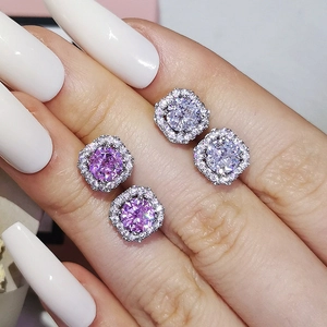Elegantly hand-held halo stud earrings featuring pink and white stones in a silver setting