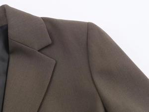 Close-up of shoulder seam and lapel detail on a dark brown blend blazer for women