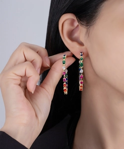 Detail of large hoop earrings with multi-colored crystals and polished silver finish