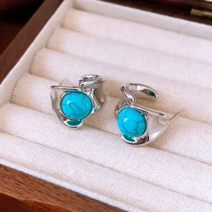 Boucles d'oreilles vintage argent avec turquoises dans des montures métalliques sur socle