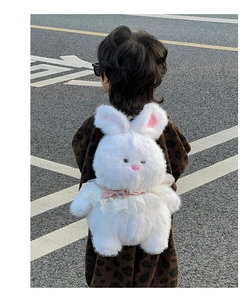 Outdoor back view of a plush white rabbit backpack for kids with soft fur texture