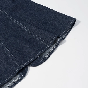 Vue détaillée des coutures contrastées blanches sur le denim bleu foncé de l'ourlet