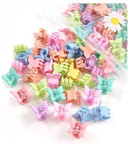 Close-up of assorted colorful mini butterfly hair clips scattered on a white surface