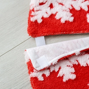 Christmas tree skirt with red and white snowflake patterns and plush fabric finish
