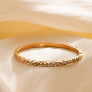 Detailed view of a gold-plated titanium steel hinged bracelet with full zircon inlay