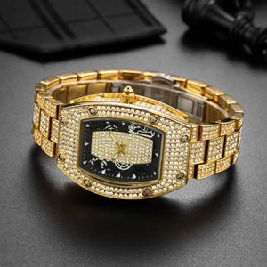 Iced-out gold tonneau quartz watch with full crystal pavé on black background