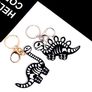 Pendentifs squelette de dinosaure avec fermoirs or et argent sur fond bicolore moderne