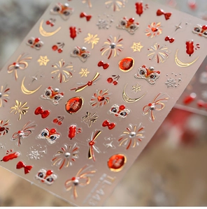 Macro shot of Lunar New Year nail stickers with red lion dance and gold foil details