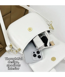 Internal storage capacity of white PU leather saddle bag with gold hardware and phone