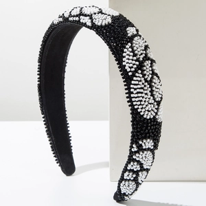 Détail d'un serre-tête fait main orné de perles de rocaille aux motifs floraux noir et blanc