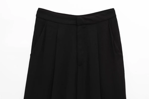 Detailed close-up of high-waisted black wide-leg trousers with elegant pleats and side pockets