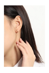 Close-up of gold S925 sterling silver huggie earrings with textured crushed gold finish