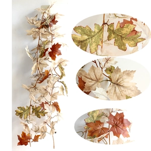 Detail of autumn maple leaf garland with white pumpkins for Thanksgiving decor