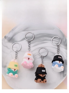 Detailed view of four colorful sleeping bear PVC keychains on a marble display
