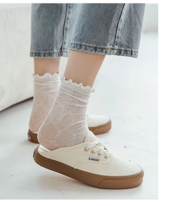 Detailed close-up of white breathable lace mesh socks with elegant ruffle cuffs