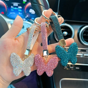Detailed view of sparkling butterfly keychains with rhinestones in silver, pink, and teal